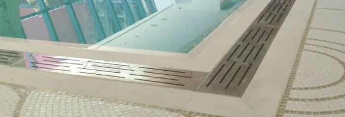 Installed stainless overflow grating running around a pool perimeter with a mitred corner
